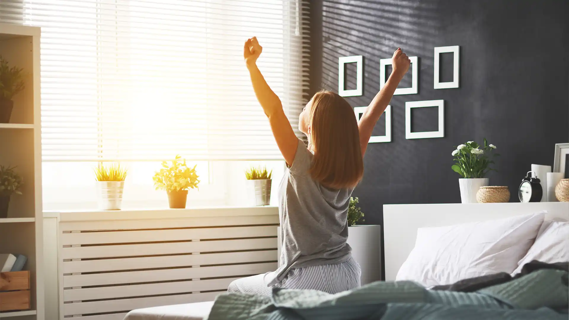 human-centric lighting - Women getting out of bed with light streaming through the window