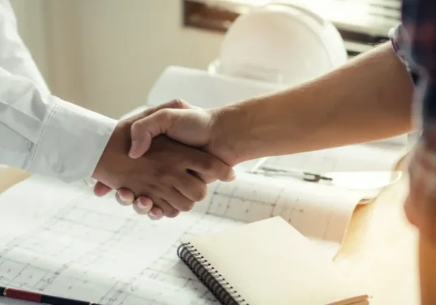 Independent lighting and illumination engineer reviewing plans with a project manager on site